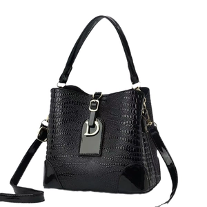 Black crocodile embossed bucket bag with gold D-ring pendant and adjustable strap
