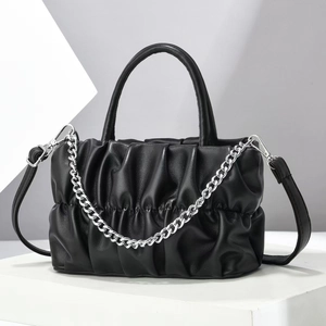Macro shot of black ruched cloud bag detailing silver chain and soft leather texture