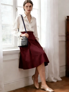 Sac seau noir et blanc porté avec chemise en soie blanche et jupe midi bordeaux