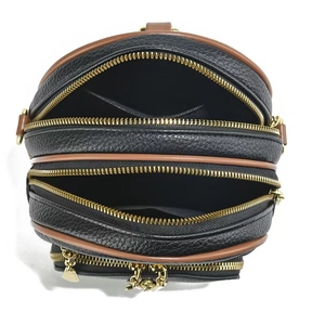 Top view of multi-compartment leather shoulder bag showing triple zipper storage design