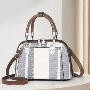 Fashionable grey striped crossbody handbag with brown leather handles and adjustable strap