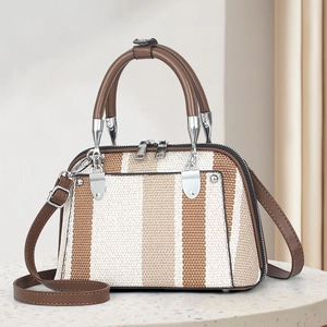 Detail of striped woven fabric and brown leather handle on a chic crossbody shell bag