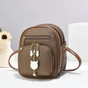Minimalist brown litchi pattern crossbody bag with golden cat pendant and triple zippers