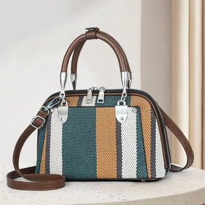 Detail of woven striped handbag with brown leather straps and silver hardware accents