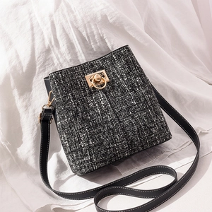 Sac seau en tweed classique avec bordures en cuir noir et détails dorés élégants