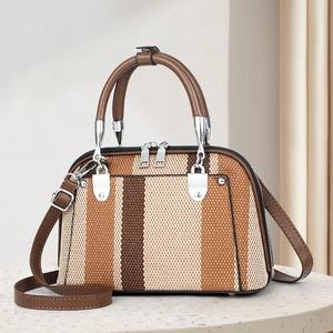 Detail of vintage striped woven handbag with brown leather handles and silver hardware
