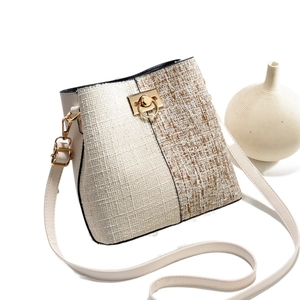 Sac seau bicolore tressé avec fermoir doré et bandoulière en cuir blanc