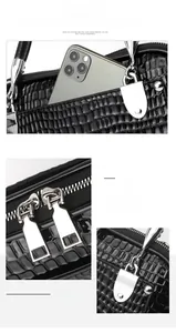 Detail of black crocodile texture handbag with silver hardware and front pocket feature