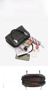 Spacious interior of black crocodile embossed handbag showing high capacity for iPad and makeup