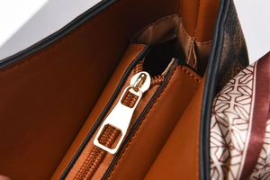Detail of caramel leather tote with gold-tone hardware and decorative silk scarf