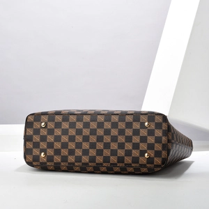 Bottom view of checkerboard tote bag with protective gold studs and leather texture