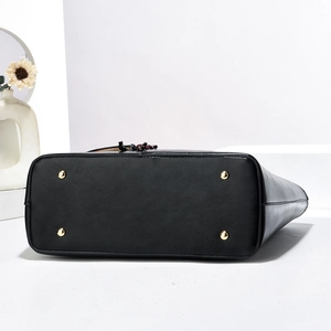 Vue détaillée du fond d'un grand sac cabas noir avec des clous de protection dorés