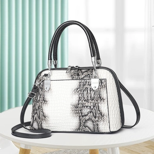 Fashionable snakeskin print shell handbag with black top handles and silver hardware