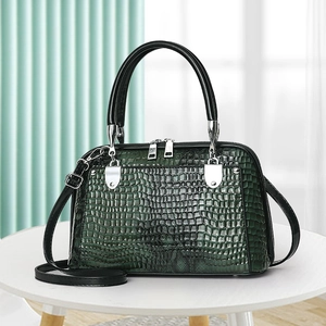 Dark green faux crocodile skin dome handbag with black handles and silver hardware