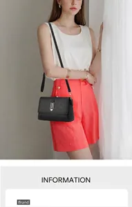 Detail view of a black crossbody bag featuring a golden U-shaped buckle and grain texture