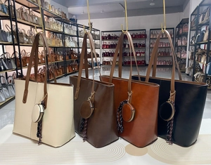 Détail de grands sacs cabas avec mini pochettes assorties et breloques à pompons tressés