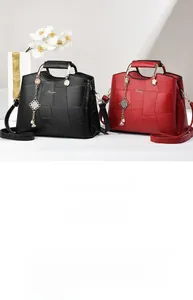 Detail of color-block geometric stitching handbags with gold handles and charms