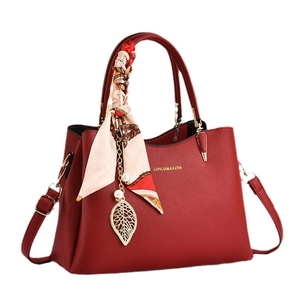 Borsa a mano rossa in pelle martellata con foulard floreale e ciondolo a foglia