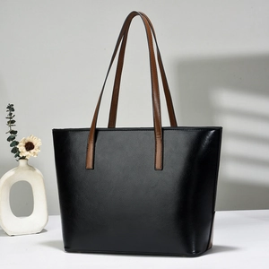 Minimalist black tote bag with brown straps and stylish shadow lighting detail