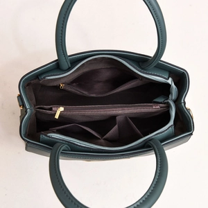 Vue détaillée de l'intérieur d'un sac vert foncé avec plusieurs compartiments de rangement