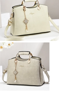 Detail of light cream green handbag with geometric patterns and gold metal handles