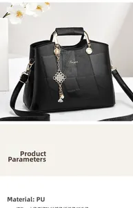 Detail of black stone-textured PU handbag with Chinese knot pearl charm and gold logo