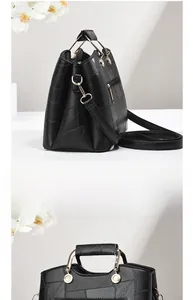 Detail of stone textured handbag with golden ring hardware and detachable shoulder strap