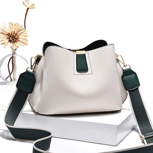 Mini sac seau blanc motif litchi avec bandoulière verte sur support blanc