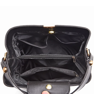 Interior view of black bucket bag with three compartments and gold magnetic buckle
