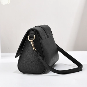 Detail of black litchi grain leather crossbody bag with premium gold metal hardware hooks