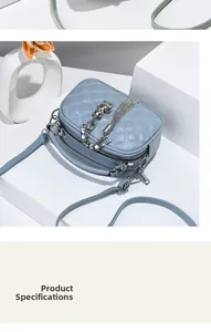 Close-up of light blue quilted camera bag featuring silver chain tassel and bear charm