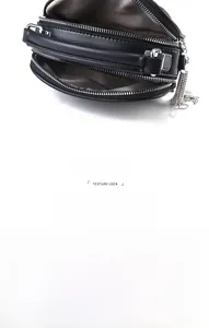 Macro shot of black quilted mini bag with dual zippers and multi-compartment interior space