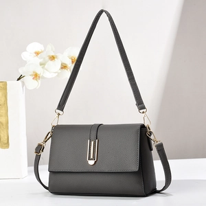 Grey pebbled leather shoulder bag with a gold rectangular metal buckle and flap