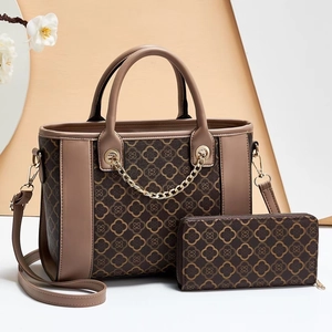 Detailed set of brown floral print tote bag and matching long zipper wallet on a pedestal
