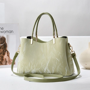 Makroaufnahme der hellgrünen Handtasche mit Marmorstruktur und gewelltem Rand