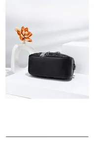 Detail showing the bottom of a black quilted leather bag with elegant silver tassel charms