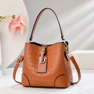 Brown crocodile embossed bucket bag with top handle and gold D-charm detail