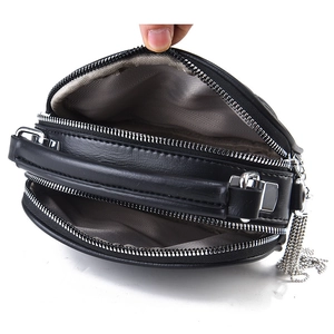 Black pebbled leather crossbody bag with three zip compartments and silver tassels