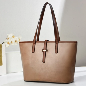 Dettaglio della borsa tote marrone vintage con chiusura in metallo dorato e manici