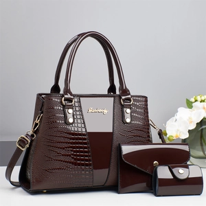Détail de la texture crocodile marron foncé et de la boucle en métal sur le sac à main