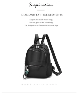 Détails d'un sac à dos noir en tissu oxford avec fermetures éclair argentées et breloque étoile