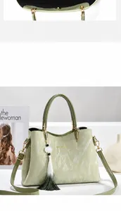 Nahaufnahme hellgrüne Handtasche mit Marmortextur, Goldbeschlägen und Farbverlauf Quaste