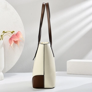 Vista laterale della borsa tote bicolore crema e marrone in ecopelle dalla texture fine