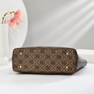 Vue du fond du sac cabas marron avec motif logo et quatre pieds de protection en métal