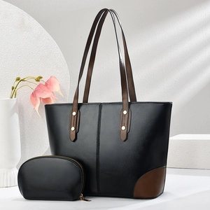 Grande borsa tote nera con manici marroni e portamonete coordinato su sfondo estetico