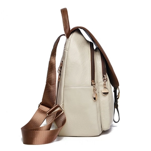 Detail view of the side double zippers and textured off-white leather of this backpack