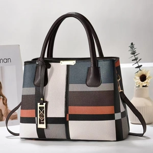 Détail du sac à main rayé multicolore avec panneaux en cuir géométriques et dorures