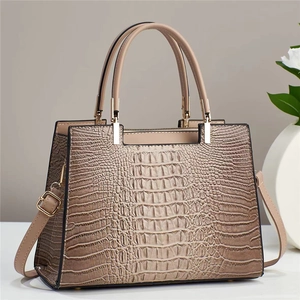Close-up of crocodile embossed texture and gold hardware on professional tote bag