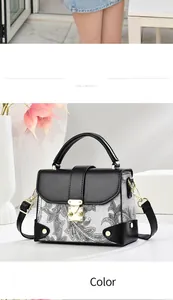 Detail of black printed handbag with golden clasp and elegant paisley pattern