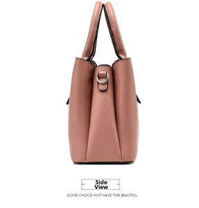 Side view of pink pebbled leather handbag with silver D-rings and accordion pleat design